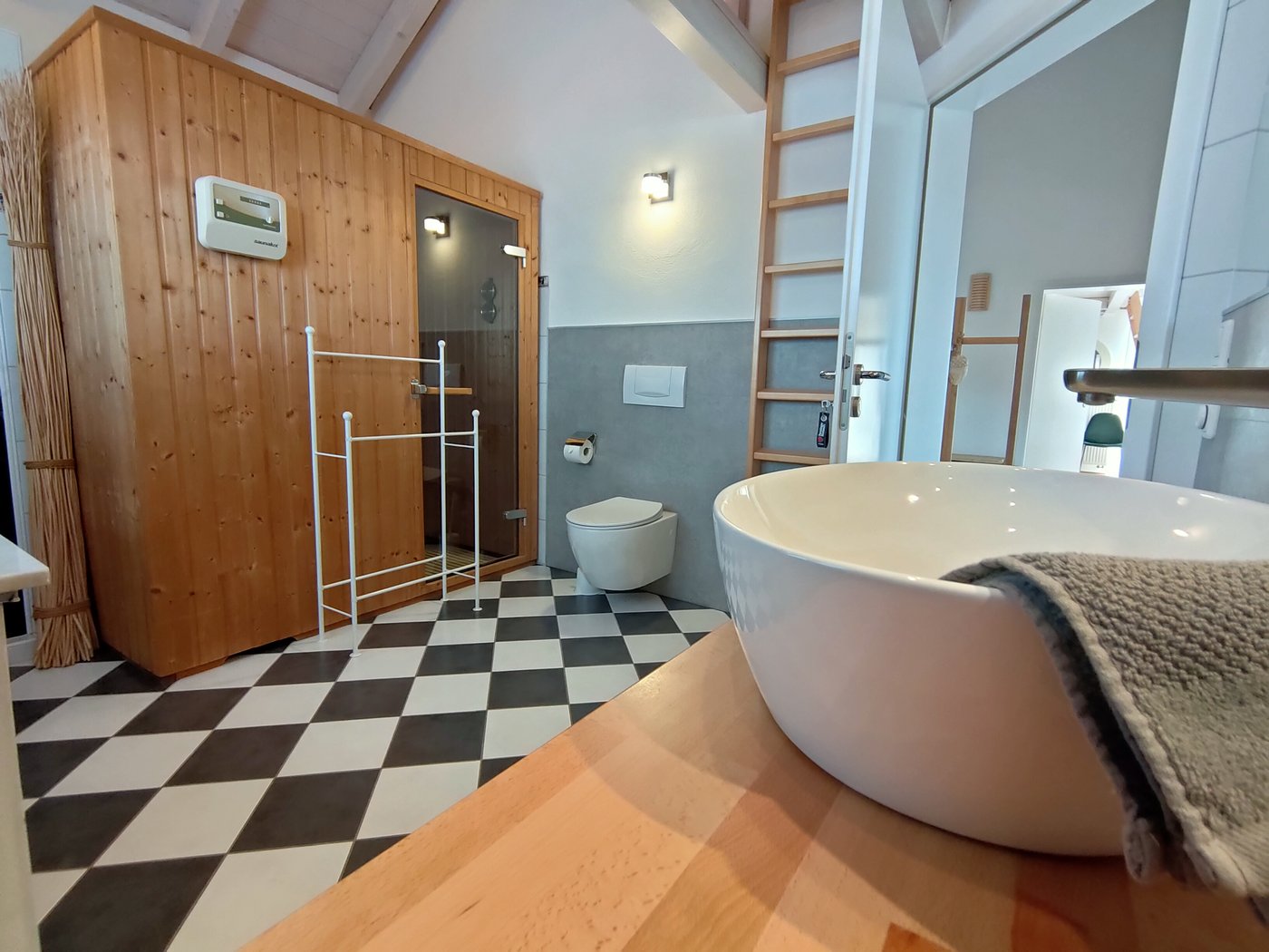 Finnische Sauna, WC und Waschtisch im ersten Badezimmer der Ferienwohnung Panorama