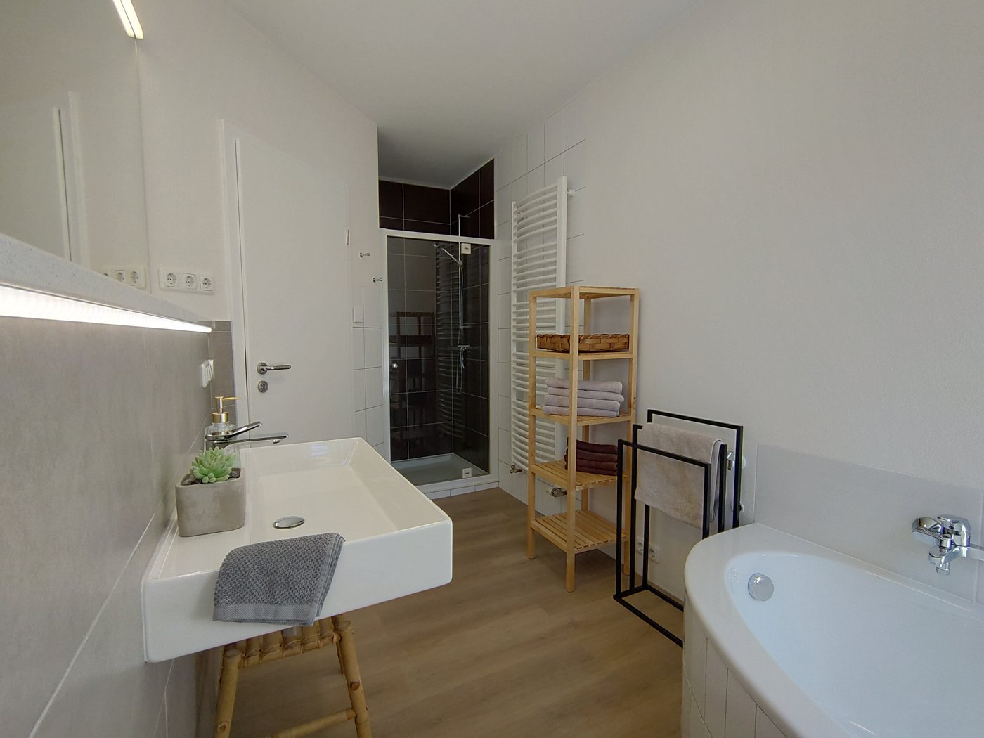 Waschtisch, Dusche und Badewanne im Badezimmer der Ferienwohnung Paradies